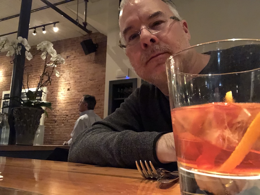 Mark in his happy place at the Kitchen in Boulder, Colorado with his favorite cocktail, the Negroni, close at hand.
